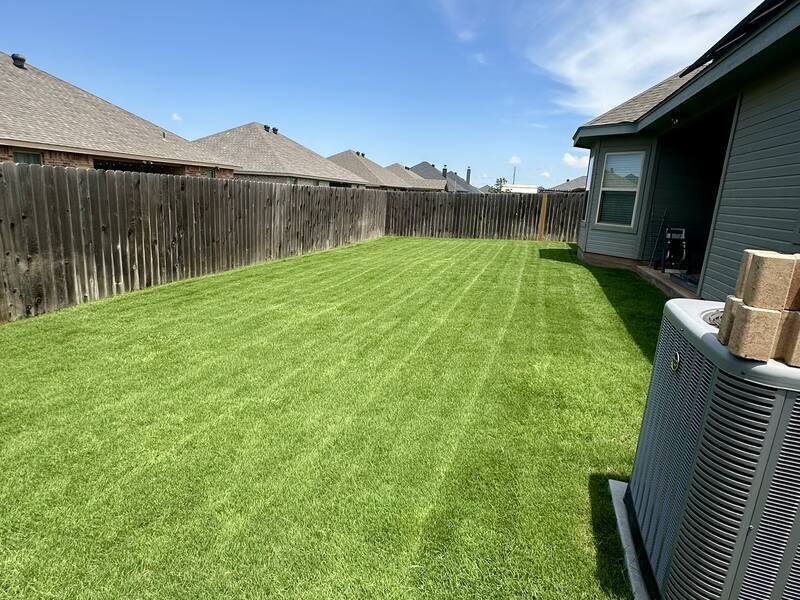 Fenced back yard in Abilene with fresh, even mowing stripes
